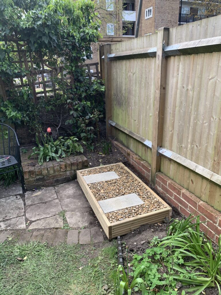 Two feet set in concrete, surrounded by pebbles, allows condensate to soak away into the ground